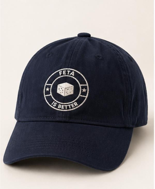 Navy blue cap with 'FETA IS BETTER' logo on a light beige background